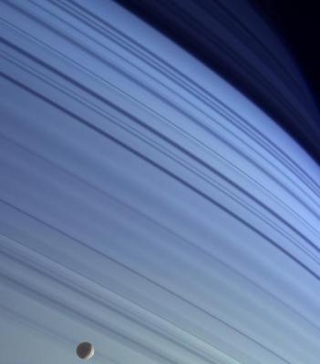 Mimas seen against Saturn\'s rings